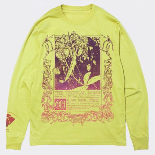 A lime-green long-sleeve shirt with a vintage-style, art nouveau inspired illustration and text in purple and coral. The design features tropical plants and ornate borders, with the words "The Tropical Dome" and "Milwaukee Mitchell Park Conservatory". Below is an excerpt from an Edgar Allen Poe poem, reading: "We had always dwelled together, beneath a tropical sun, in the Valley of the Many-Colored Grass. No unguided footstep ever came upon that vale; for it lay away up among a range of giant hills that hung beetling around about it, shutting out the sunlight from its sweetest recesses."