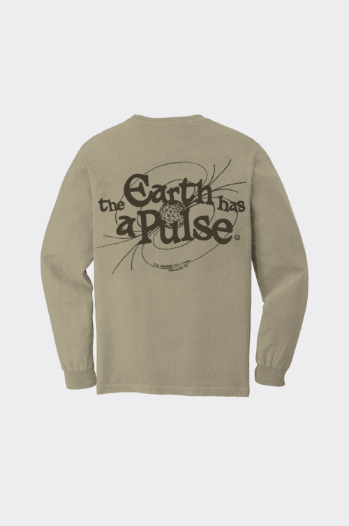 A khaki long sleeve t-shirt with brown text and design on the back. The text reads, "the Earth has a pulse" with a surrounding illustration resembling an orbit and a globe at the center. Additional smaller text below the design reads "Mitchell Park Domes / Milwaukee, WI".